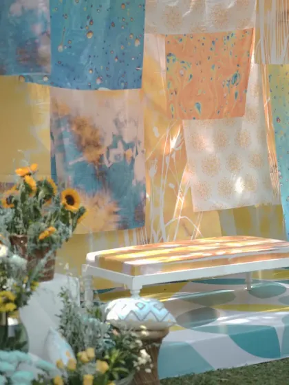 A close-up of the seating on the Haldi stage, with a custom-painted bench and backdrop of layered, colorful fabrics.