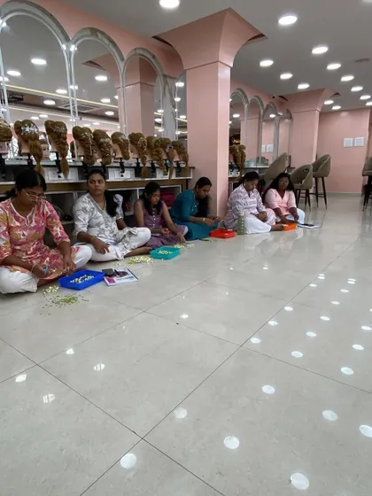 Students sitting together and practicing their flower-making skills.