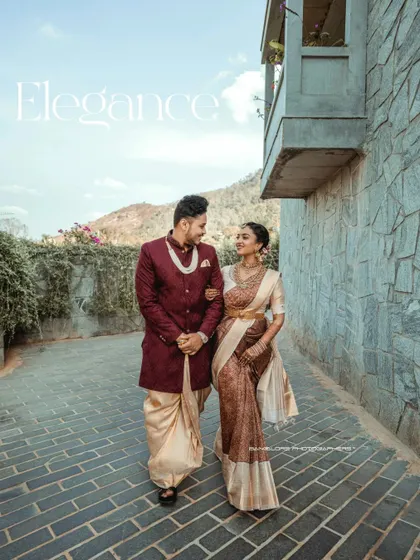 Walking together on a cobblestone path, this image has a timeless, elegant feel. It showcases the couple's beautiful traditional attire in a grand, architectural setting.