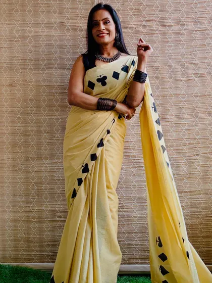 A subtle yellow cotton mulmul saree with a quirky card suit print. It's a fun and unique design that adds a playful touch to your look.