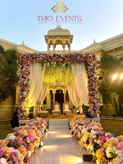 The view down the floral aisle towards the stunning mandap. The combination of lush flowers and elegant drapery creates a scene of pure romance.