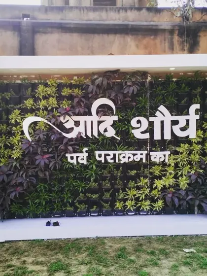 The event-specific living wall in daylight, with the custom Hindi lettering clearly visible against the green and purple plants.