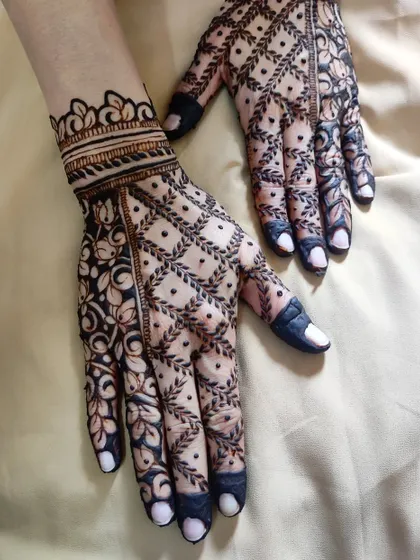 A minimal back-hand design for a bride, featuring a beautiful net pattern and floral border.