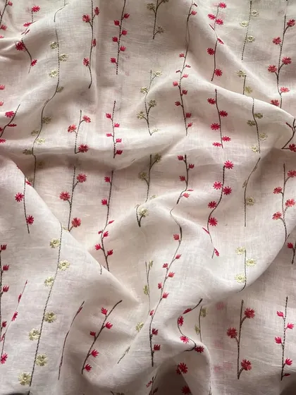 This embroidered linen features delicate floral sprigs on a white base, offering a simple, subtle, and stunning look for everyday wear.