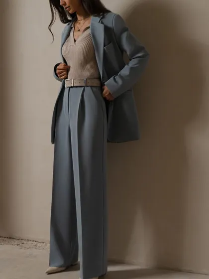 I love playing with proportions, like in this dusty blue suit. It features a classic blazer paired with pleated, wide-leg trousers for a relaxed yet sophisticated look.