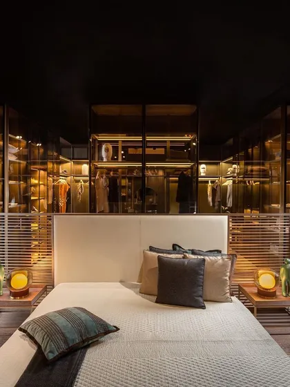 Here, I've used a see-through island wardrobe to create a subtle partition between the sleeping and dressing areas. This approach opens up the bedroom, merging the two spaces into one grand suite while showcasing your finest pieces like works of art.