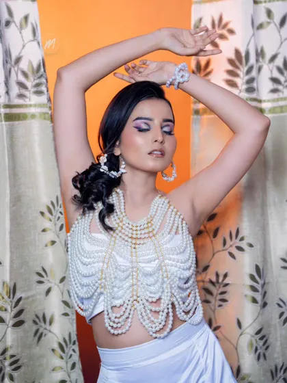 A close-up of the pearl top and the beautiful, artistic makeup.