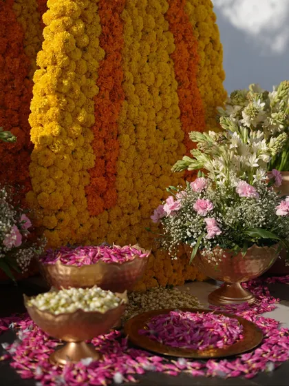 A close-up of the offering bowls filled with fresh flower petals in shades of pink, white, and yellow, ready for the ceremony.