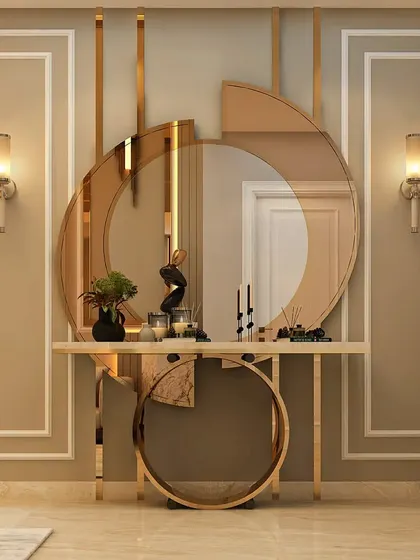 An abstract and artistic foyer design. The console table appears to be supported by a large golden ring, with a deconstructed mirror above it, creating a sculptural and memorable entrance.