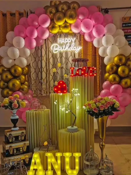 An elegant and romantic birthday decoration perfect for a surprise at home. The pink, white, and gold balloon arch, combined with light-up letters and props, creates a warm and celebratory feel.