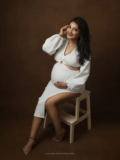 A modern and stylish maternity portrait in a white cutout dress, showing that maternity fashion can be chic and contemporary.