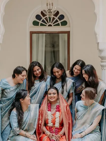 A lovely group portrait of the bride surrounded by her adoring bridesmaids, all dressed in coordinated blue sarees.