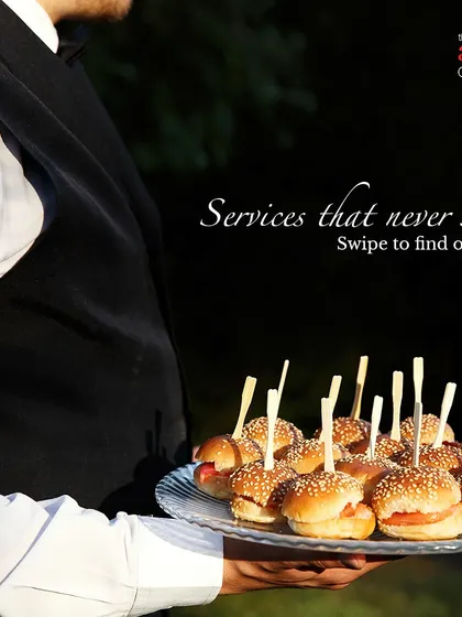 Our staff serving mini burgers at an outdoor event. We cater to high-teas, corporate gatherings, and launch events with a wide range of bite-sized snacks and appetizers.