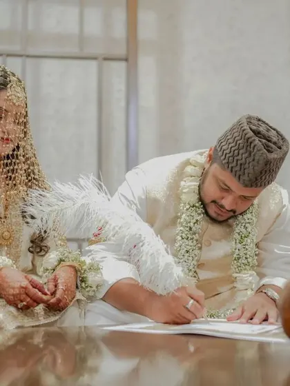 The groom signs the marriage contract during the Nikah ceremony, a solemn and important moment.