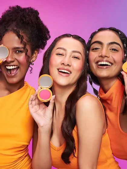 This shot for Joyology Beauty showcases bright, playful blush application. The models' makeup is energetic and youthful, with a focus on rosy cheeks and radiant smiles to advertise the blush compacts.