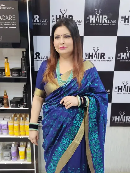 A happy client posing in the salon after her hair color service. Her new color and style look elegant and perfectly suited for her.