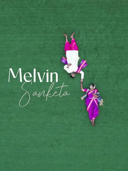 A creative, top-down drone shot of a couple in traditional Marathi attire lying on a field of green, holding hands. It's an artistic and unique perspective.