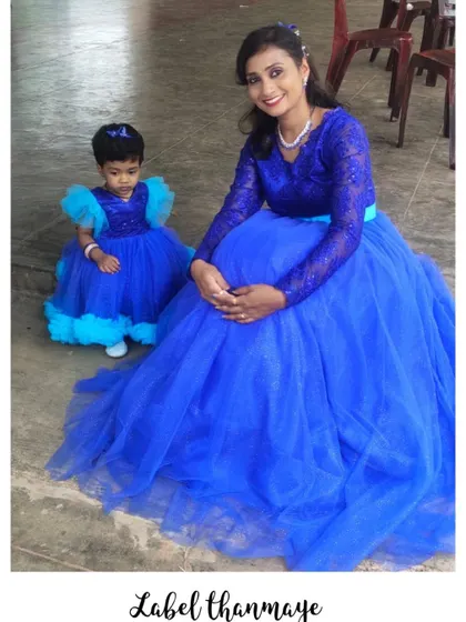 A beautiful royal blue twinning set for a mother and her little one. The mother's gown has delicate lace sleeves, while the daughter's frock has cute tulle shoulder details.