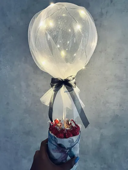 A hand-held view of the light-up balloon hamper, showing its scale and enchanting glow.