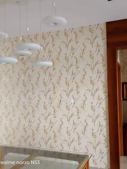 A delicate branch wallpaper in a hallway, complementing the modern light fixtures.