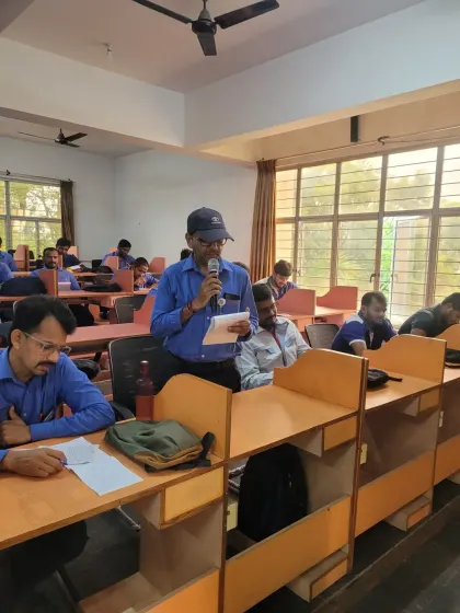A participant at Toyota Kirloskar confidently speaks into the microphone, demonstrating the progress made during our English communication workshop. Our goal is to build both skills and confidence.