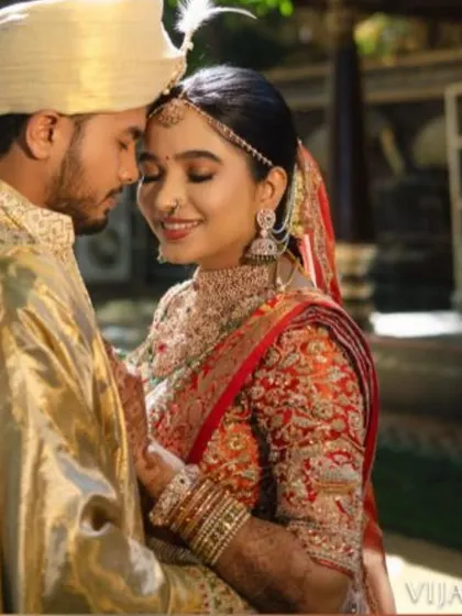 A duplicate image of 54, showing the groom in a grand gold sherwani, perfectly complementing his bride's red and gold attire for a truly royal wedding look.