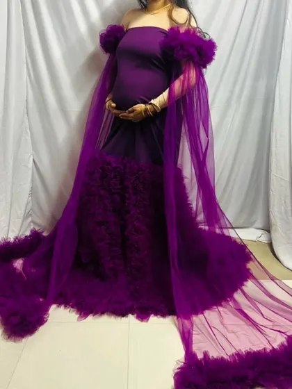 This angle showcases the full length of the sheer cape and the rich texture of the ruffled train on this purple maternity gown.