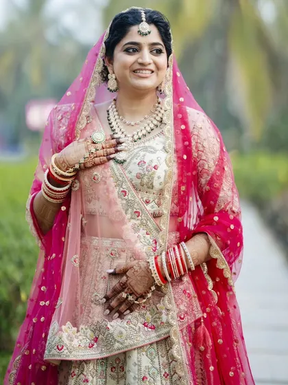 A close-up of the bride's happy face. Her makeup is soft and romantic, with a gentle pink lip and defined eyes.