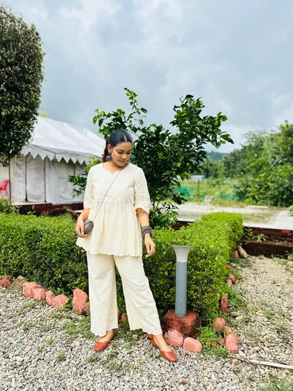 A simple and beautiful off-white co-ord set with delicate embroidery. Paired with brown juttis, it's a perfect look for a peaceful day outdoors.
