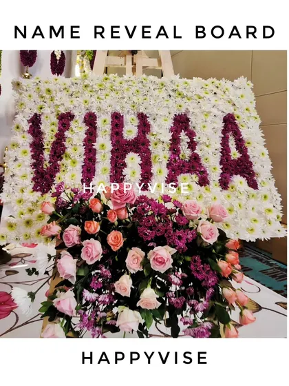 A custom name reveal board for baby Vihaa, made entirely of fresh flowers. This is a beautiful and memorable way to announce the baby's name during the ceremony.