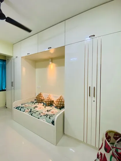 This bedroom is designed for maximum storage, with floor-to-ceiling wardrobes surrounding a cozy daybed, making it a perfect guest room or kid's room.