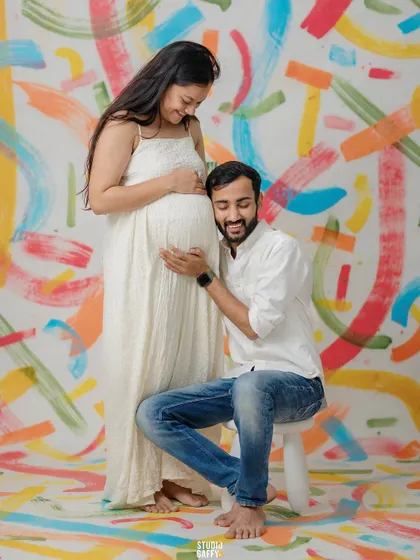 The father-to-be listens to the baby bump against our unique, custom-painted backdrop.