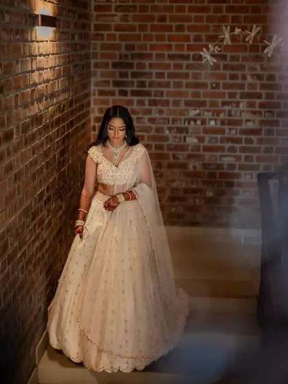 A stunning bride in a white lehenga, exuding grace and elegance. We use creative framing and lighting to capture a variety of beautiful portraits.