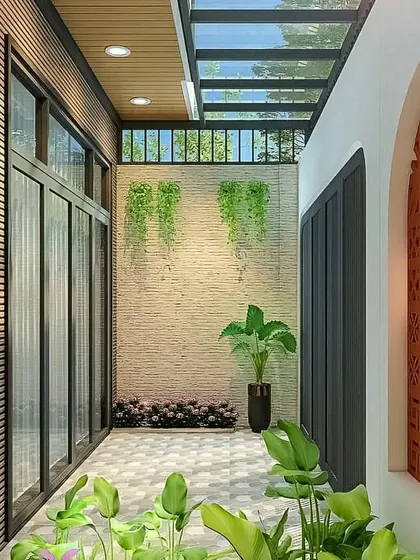 This design shows a semi-outdoor courtyard with a glass roof, patterned floor tiles, and lush greenery. The terracotta jaali wall adds a traditional and decorative touch.