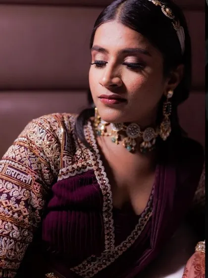 A stunning portrait of the bride in her Sabyasachi engagement outfit. The intricate embroidery on the sleeve and her elegant pose are the focus of this shot.