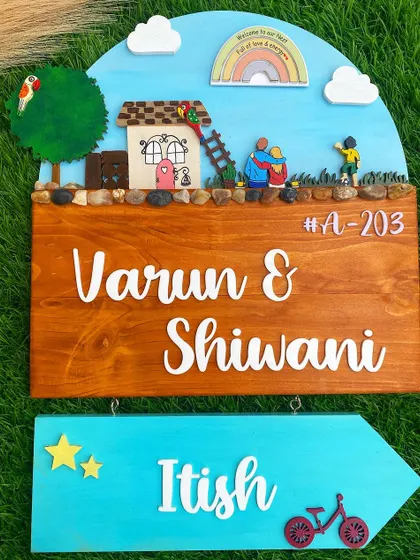 A bright and cheerful nameplate that tells a story of family life. It features parent figurines watching their child play, set against a colorful sky with a rainbow, symbolizing a home filled with love and joy.
