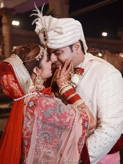 A tender moment between the bride and groom, as she gently touches his face.