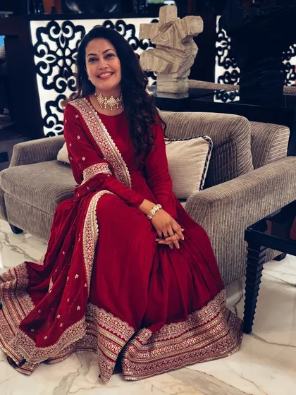 The full seated view of the stunning red Anarkali.