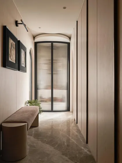 The entrance to the master suite is a long passage lined with wardrobes, leading to a Mandir as a focal point. This layout compartmentalizes the suite into dedicated functional zones for dressing, prayer, and rest.