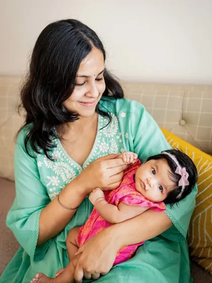 A new mom and her two-month-old baby girl sharing a sweet moment on the couch. This little one was a natural, looking right at the camera.
