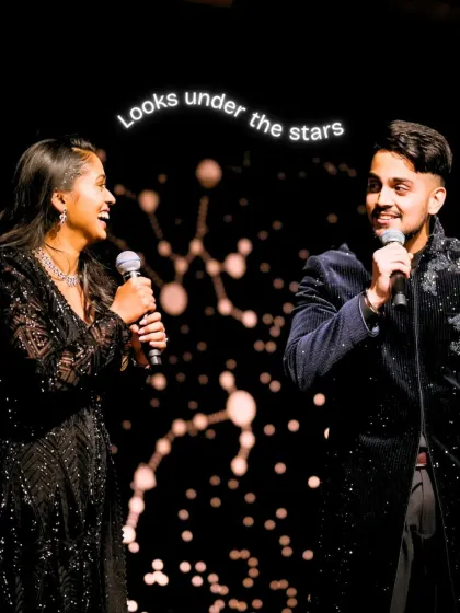 The couple performs a duet on stage, with the constellation backdrop creating a romantic and personalized setting for their performance.