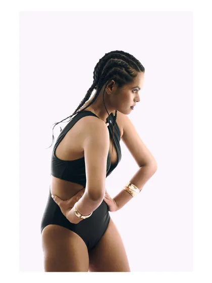 Another pose from the high-key studio series. The side profile emphasizes the model's strong posture and the clean lines of the outfit.