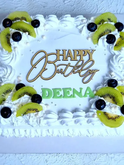 A top-down view of the Tres Leches cake, showing the arrangement of kiwi and blueberries.