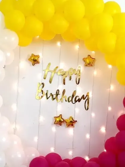 An elegant ring decoration with white, yellow, and magenta balloons, complete with fairy lights for a warm glow. This is a great setup for an evening party at home.