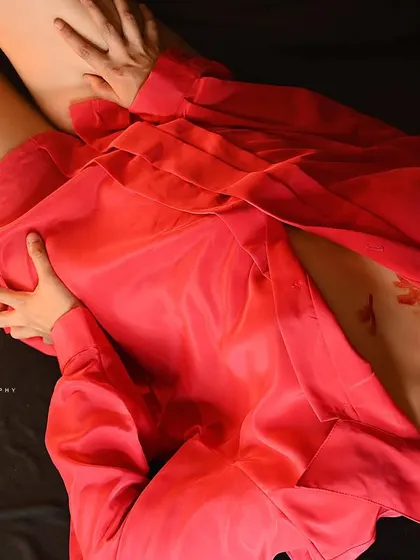 An artistic overhead shot of a model in a red shirt, with lipstick marks adding a conceptual element. This is a bold, editorial-style image.