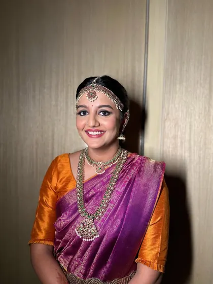 A lovely South Indian bridal hairstyle featuring a bubble braid adorned with fresh flowers and traditional temple jewellery. This is a modern interpretation of a classic look.