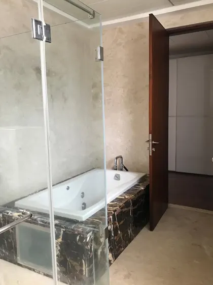 Before: The original bathroom in 'A Walk in the Clouds,' featuring a dated jacuzzi tub and dark marble.