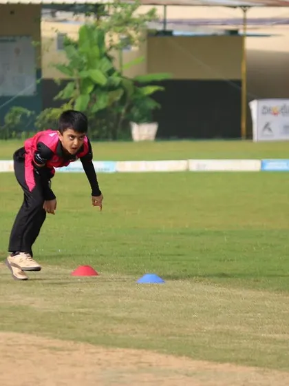 A young player participates in a fielding drill, learning the fundamentals of the game.