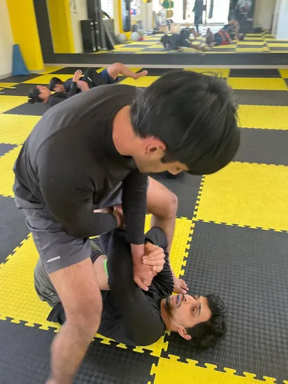 A student works to break his opponent's grip and pass the guard. Every roll is a physical and mental puzzle.