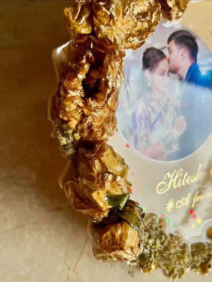 A close-up of a photo frame showing the 3D effect of preserved golden roses. This custom frame is a beautiful way to showcase wedding flowers and a favorite photo.